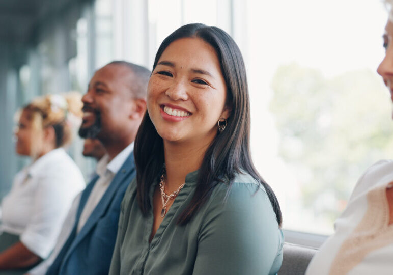 Face, recruitment or business people in a waiting room for a job interview at human resources office building. Portrait, we are hiring or excited woman in queue for an advertising agency or company.